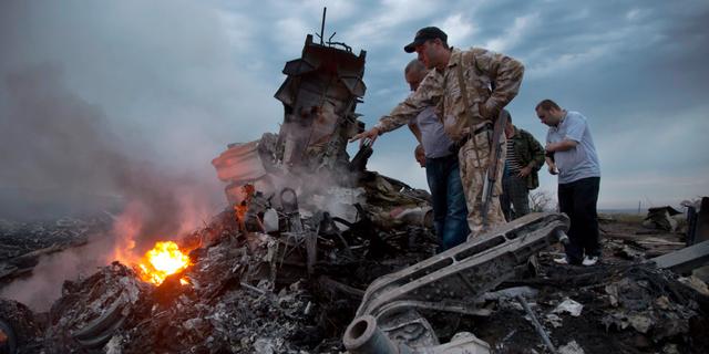 Personer inspekterar platsen där MH17 kraschade i juli 2014. Dmitry Lovetsky / AP