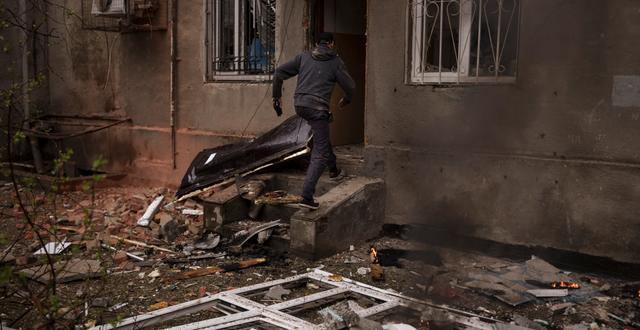 Man på väg in i sitt bombade hem i Charkiv.  Felipe Dana / AP