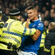 Polis tar hand om Evertons Carlos Alcaraz i samband med bråket. 