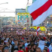 Demonstranter med den gamla belarusiska flaggan tågade genom Minsk på söndagen