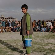 Pojke säljer vatten under ett sportevent i Kabul.