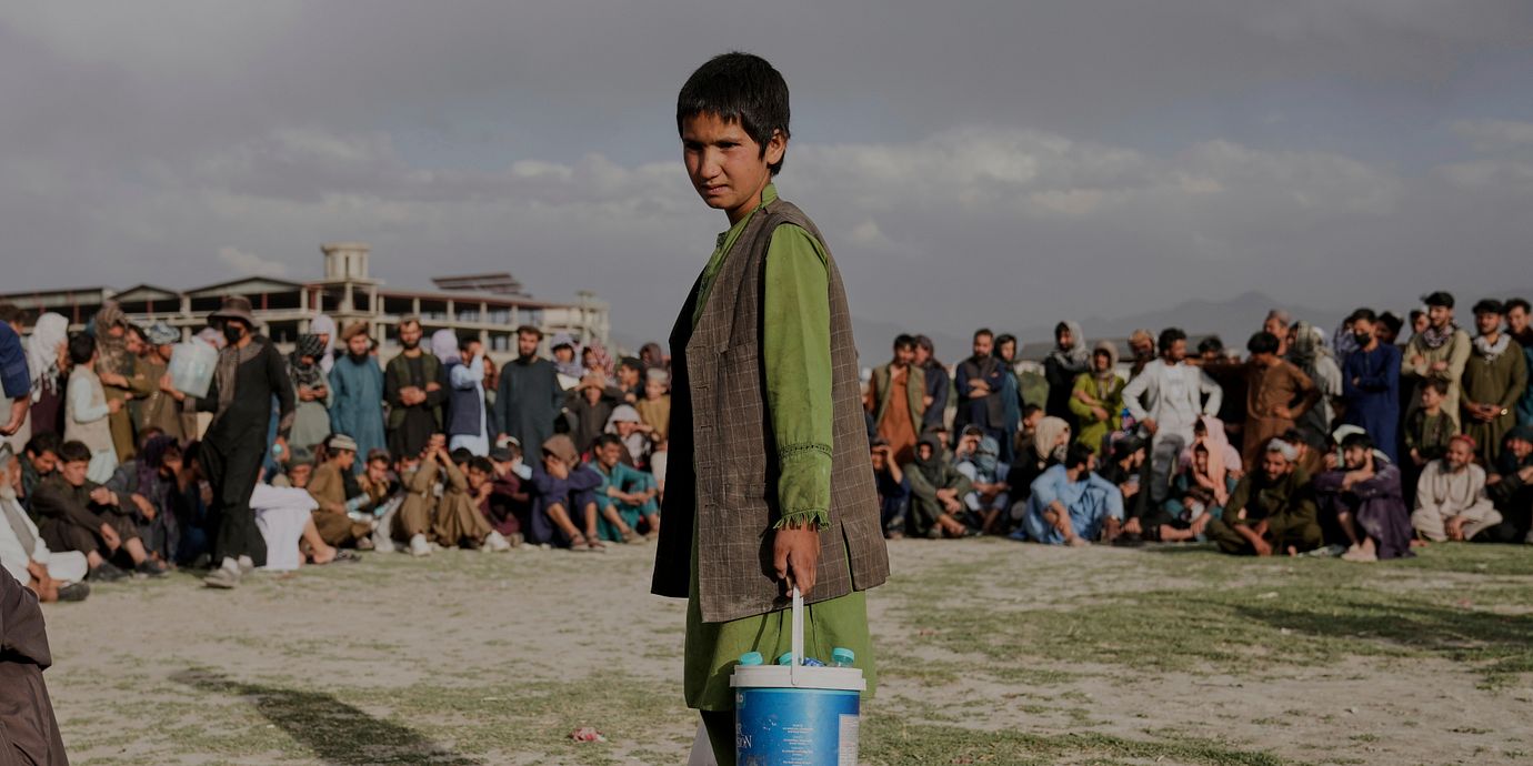 Pojke säljer vatten under ett sportevent i Kabul.