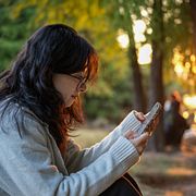 Illustrationsbild. En kvinna som använder sin telefon.