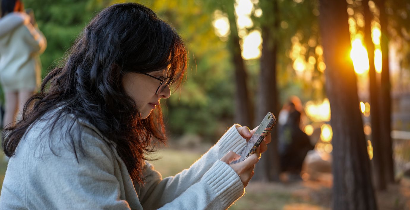 Illustrationsbild. En kvinna som använder sin telefon.