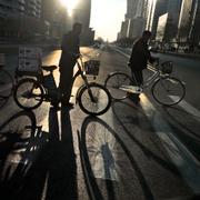The sun casts the shadows from cyclists as they cross the Mirae Scientist Street in downtown Pyongyang, North Korea, Tuesday, Nov. 26, 2019.