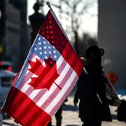 A protester holds the flags of Canada and the United States outside on Parliament Hill in Ottawa, on Saturday, Feb. 1, 2025.
