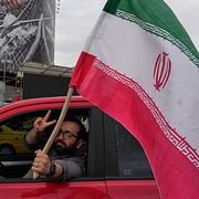 En man med en iransk flagga i Teheran den 13 april.