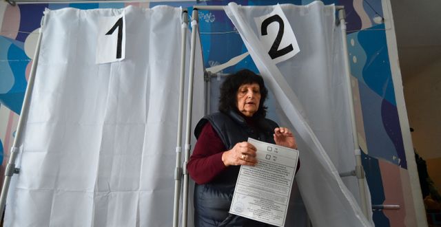 Kvinna lämnar röstbås i Melitopol, där man i september höll val om att ansluta regionen till Ryssland. Valen erkändes inte av omvärlden.  AP
