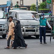 En trafikpolis dirigerar trafiken i Dhaka, Bangladesh.