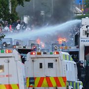 Polisen använder vattenkanoner mot demonstranter.