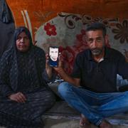 Mohammad och Tahani al-Najjar håller upp en bild på sonen Ahmad som är försvunnen.
