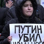 En kvinna håller i ett plakat med texten ”Putin dödade Navalnyj” under en protest i Estland.