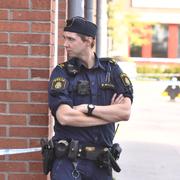 Polis vid gymnasieskola i Huddinge. 