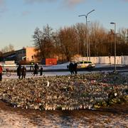 Människor tänder ljus och lämnar blommor på minnesplatsen utanför Campus Risbergska i Örebro.