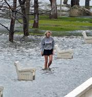 En kvinna vandrar i ett översvämmat område i Florida. Chris O'Meara / AP