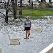 En kvinna vandrar i ett översvämmat område i Florida. Chris O'Meara / AP