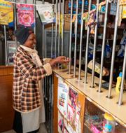 Linnah Mueni köper majsmjöl i en liten butik i Kitengela, i utkanten av Nairobi i Kenya. Mueni livnär sig på att sälja grönsaker och säger att matpriserna gjort att familjen tingas leva på ett mål mat om dagen. Khalil Senosi / AP