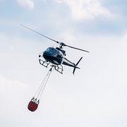 En helikopter vattenbombar vid en brand. Arkivbild.
