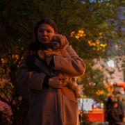 En kvinna med sin hund i samband med drönarattacken mot Kyiv under natten till lördagen. 