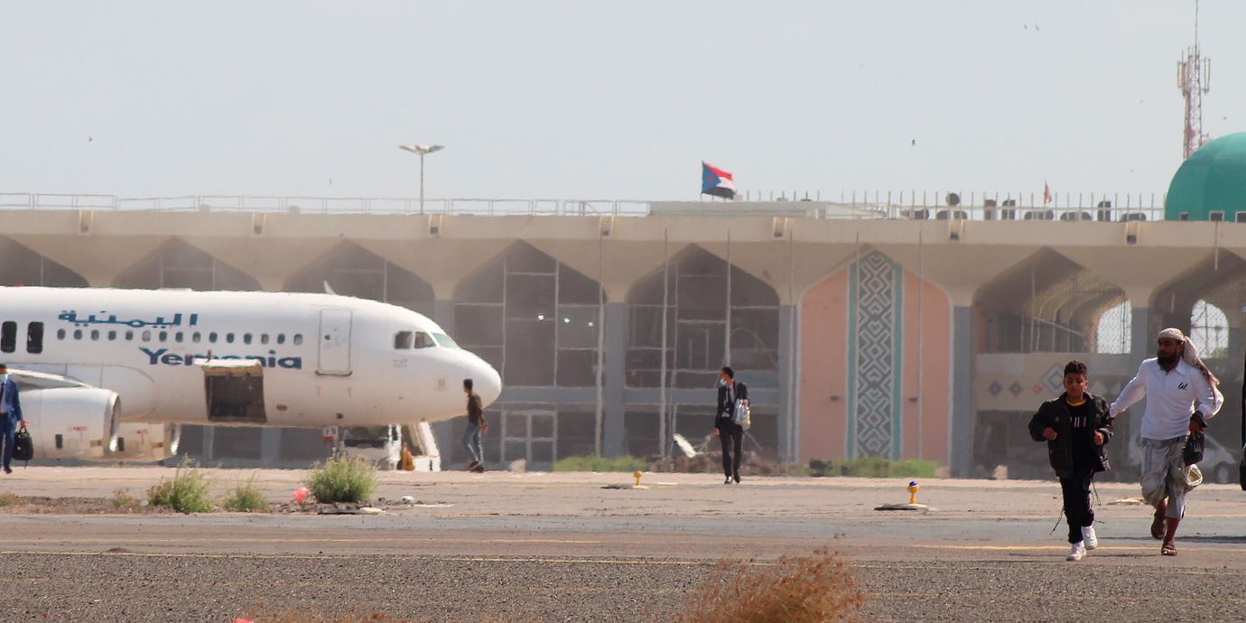 Arkivbild. Människor lämnar landningsbanan efter en explosion på flygplatsen i Aden i Jemen i december 2020.