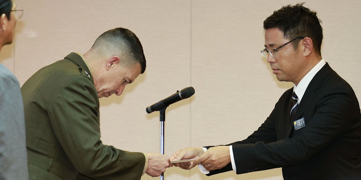 Okinawas guvernör, höger, räcker över ett officiellt protestbrev till den amerikanska marinens befälhavare.