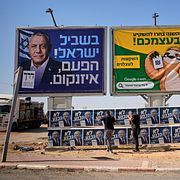 Likudaktivister sätter upp kampanjaffischer i Dimona i Israel.