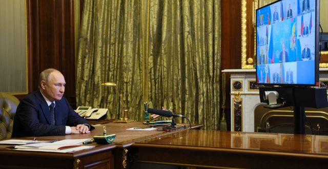 Putin sitter vid långa bord och talar med sina kollegor via videosamtal eller på avstånd.  Gavriil Grigorov / AP