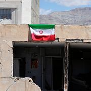En iransk flagga hänger på en byggnad som skadats i en amerikansk-israelisk attack mot huvudstaden Teheran.
