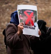 En kvinna håller upp ett fotografi av dansken Rasmus Paludan vid en protest i Turkiet i januari, efter att han bränt koraner i Sverige. Francisco Seco / AP