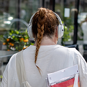 Till vänster: Person med hörlurar på gata i Stockholm i augusti 2023. Till höger: Shakira uppträder under VM-premiären i Mexiko City den 11 juni i år.
