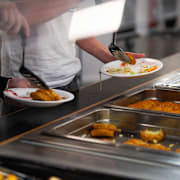 Elever tar mat i en skolmatsal. Arkivbild. 