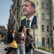 Invånare i Istanbul framför stora affischer av Erdogan. 