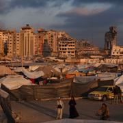 Displaced Palestinians walk through a makeshift tent camp at the Gaza City port on Thursday, May 22, 2025. 