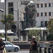 Människor framför det syriska försvarsdepartementet, som skadades i Israels angrepp. 