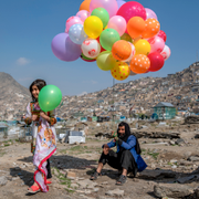 En man säljer bröd och en annan man säljer ballonger i Afghanistans huvudstad Kabul den 21 mars.