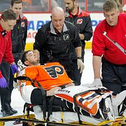 Michal Neuvirth förs av isen på en bår efter att ha kollapsat under matchen mellan Philadelphia och New Jersey.