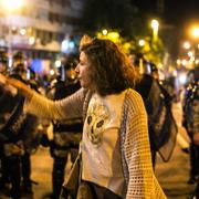 En demonstrant framför kravallpolis i Skopje