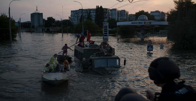 Människor flyg från sina hem i båtar. Felipe Dana / AP