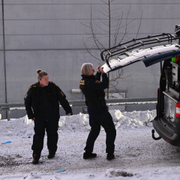 Till vänster porten till lägenhetshuset som polisen slagit in, bild från förundersökningsprotkollet. Till höger polisens tekniker 8 januari.