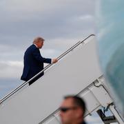 President Donald Trump på väg ombord planet i Alaska.