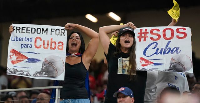 Demonstranter håller upp plakat med texten ”Frihet för Kuba” under en baseballmatch mellan Kuba och USA i Miami den 19 mars 2021.  Wilfredo Lee / AP