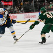 St Louis Justin Faulk skjuter förbi Minnesotas Jared Spurgeon. 