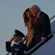 Mika Zibanejad trycker till en mostpelare under OS-matchen mellan Sverige och Finland. Till höger syns Donald och Melania Trump kliva av flygplanet. 