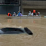 Räddningsarbetare thar sig fram på båt i Songkhlaregionen.
