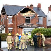 Brandmän inspekterar ett hus som skadats av stormen Éowyn i Belfast i Nordirland.