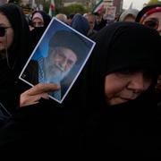 En demonstrant håller upp en bild av Ali Khamenei under protester mot USA:s angrepp i Teheran. 