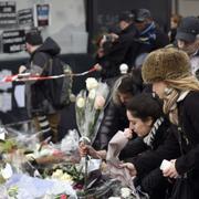 Människor lägger ner blommor vid den judiska matbutiken i Porte de Vincennes i Paris där fyra dödades vid terrordådet i januari.