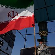 En kvinna med en iransk flagga i Teheran.