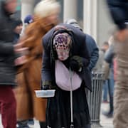 En kvinna tigger på gatan i Milano.