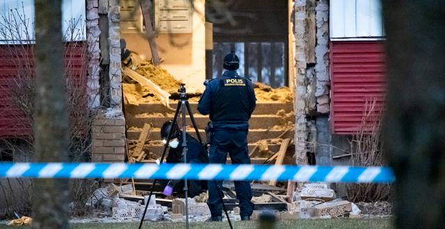 Polisens kriminaltekniker undersöker den skadade entrén till ett flerfamiljshus i Höganäs efter en kraftig detonation på tisdagsmorgonen. Johan Nilsson/TT / TT NYHETSBYRÅN